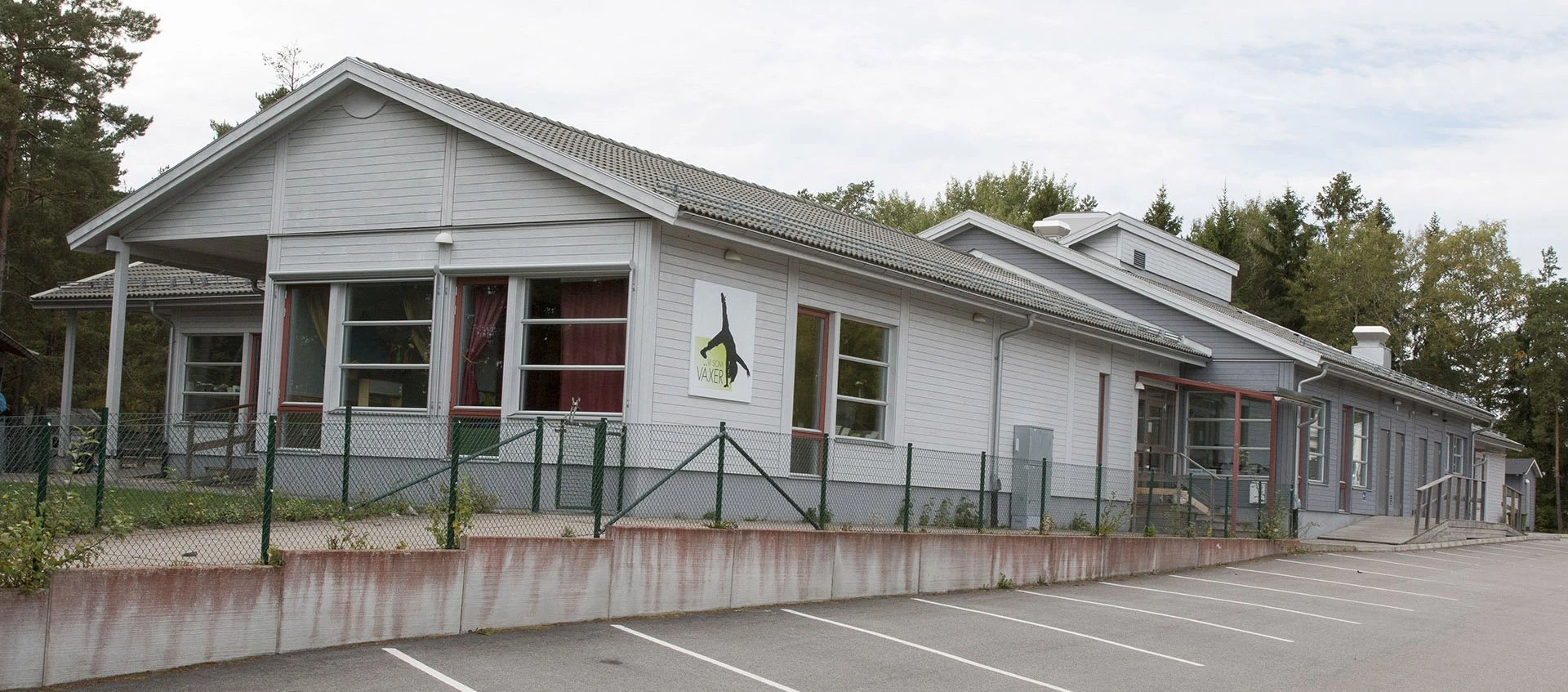 Förskolan Rensättra, hela förskolan på bild bakom parkering och staket