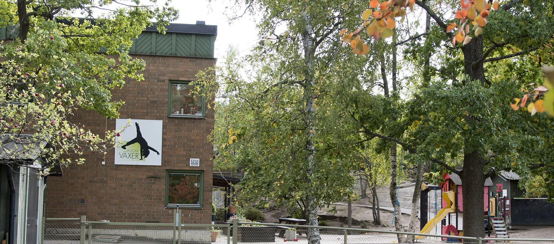 Fasaden på Förskolan Helge, och klätterställningar på gården